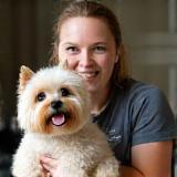 Amanda Jones, Lead Groomer, holding a happy dog.
